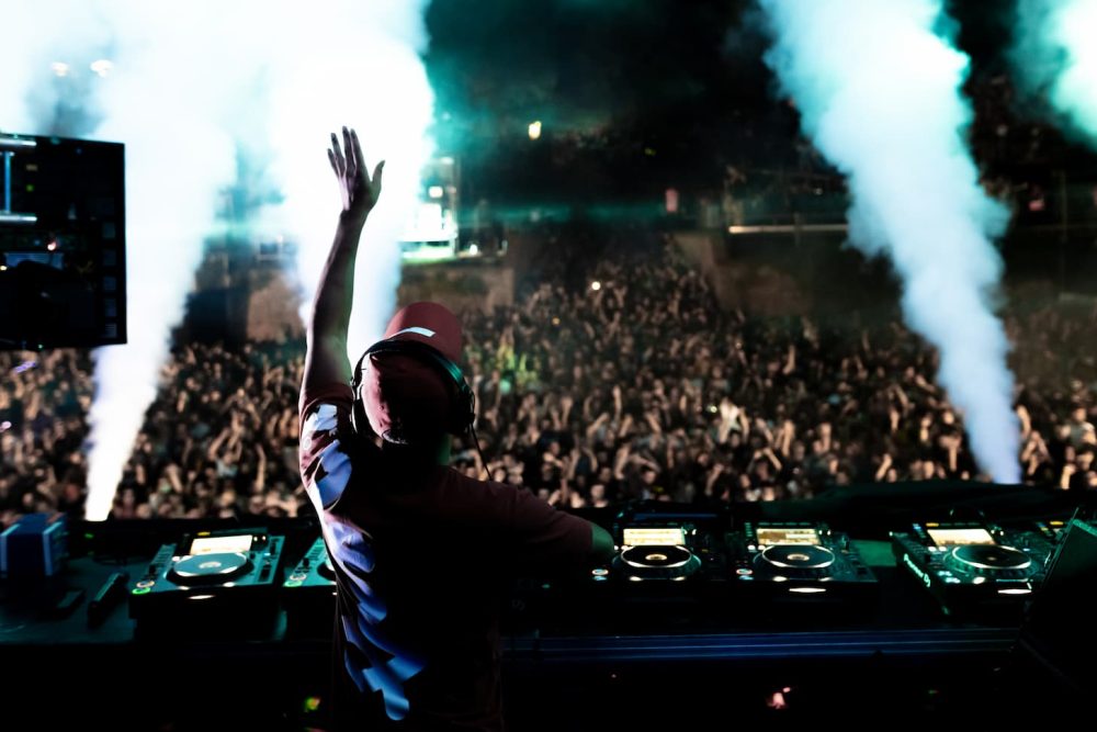 rear-view-dj-playing-music-front-excited-crowd-music-festival-by-night (1)